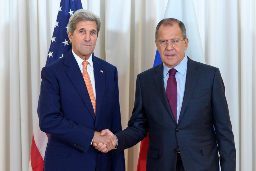 USA:s utrikesminister John Kerry och hans ryske kollega Sergej Lavrov skakar i samband med maratonförhandlingar i Genève. (Foto: Martial Trezzini/AP/TT)