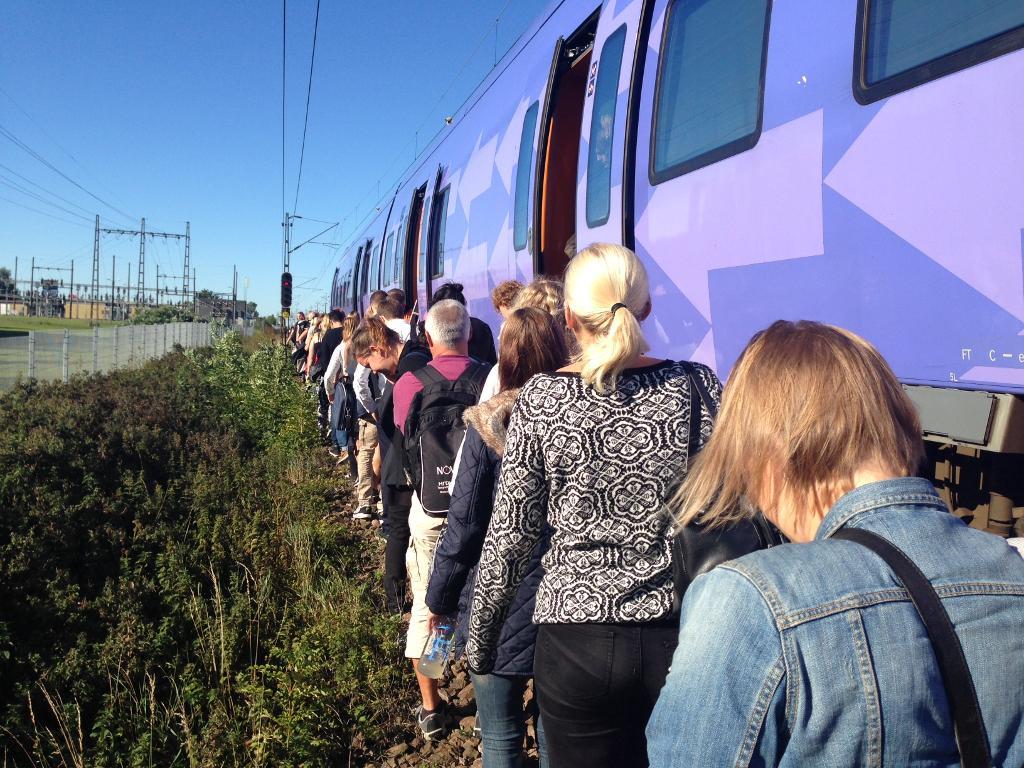 Passagerare evakueras från ett Pågatåg i Burlöv. En nedriven kontaktledning har orsakat stopp i all tågtrafik mellan Lund och Malmö sedan kvart i åtta i morse. (Foto: Cecilia Klintö/TT)