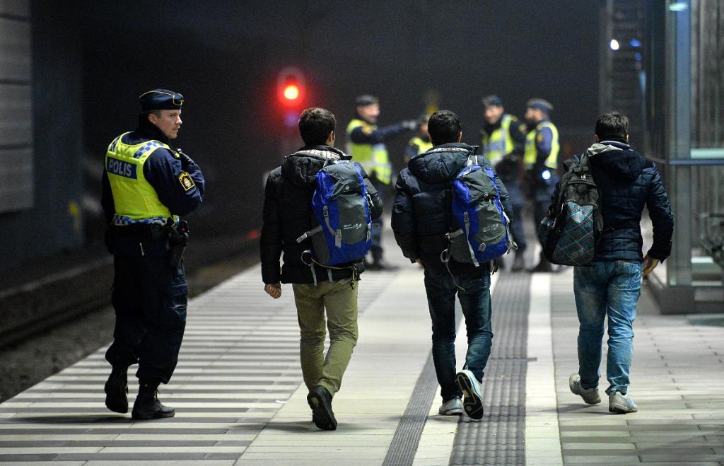 Polis eskorterar asylsökande från ett Öresundståg som stannat vid Hyllie station utanför Malmö efter genomförd gränskontroll. Bilden är från i december i fjol. (Foto: Johan Nilsson / TT)