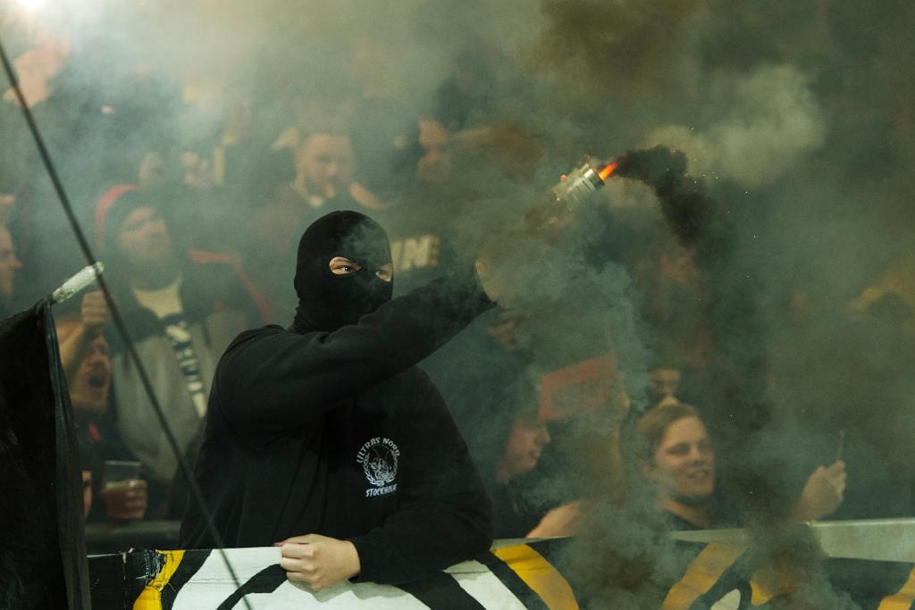 Maskerad man med en bengalisk eld i AIK:s klack under förra veckans allsvenska match mellan Djurgården och AIK på Tele2 Arena i Stockholm. (Foto: Stina Stjernkvist/TT)