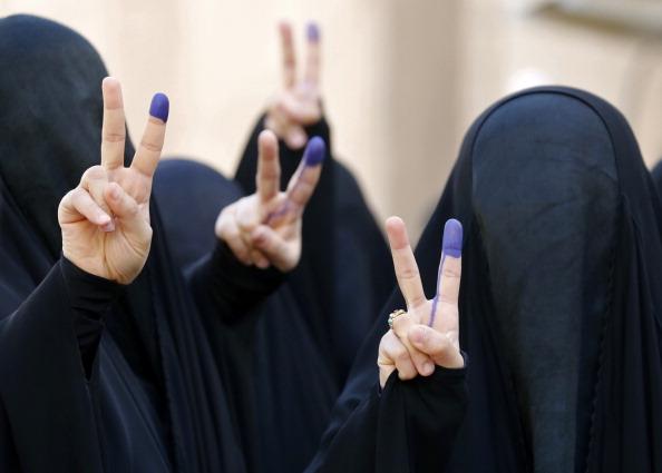 Helt täckta kvinnor i burka gör segertecken after att ha röstat i Iraks första parlamentariska val efter att USA:s trupper dragit sit tillbaka. Kvinnor i norra Irak har haft burka-tvång, men nu förbjuds burkan av IS.  (Foto: Sabah Arar/AFP/Getty Images)