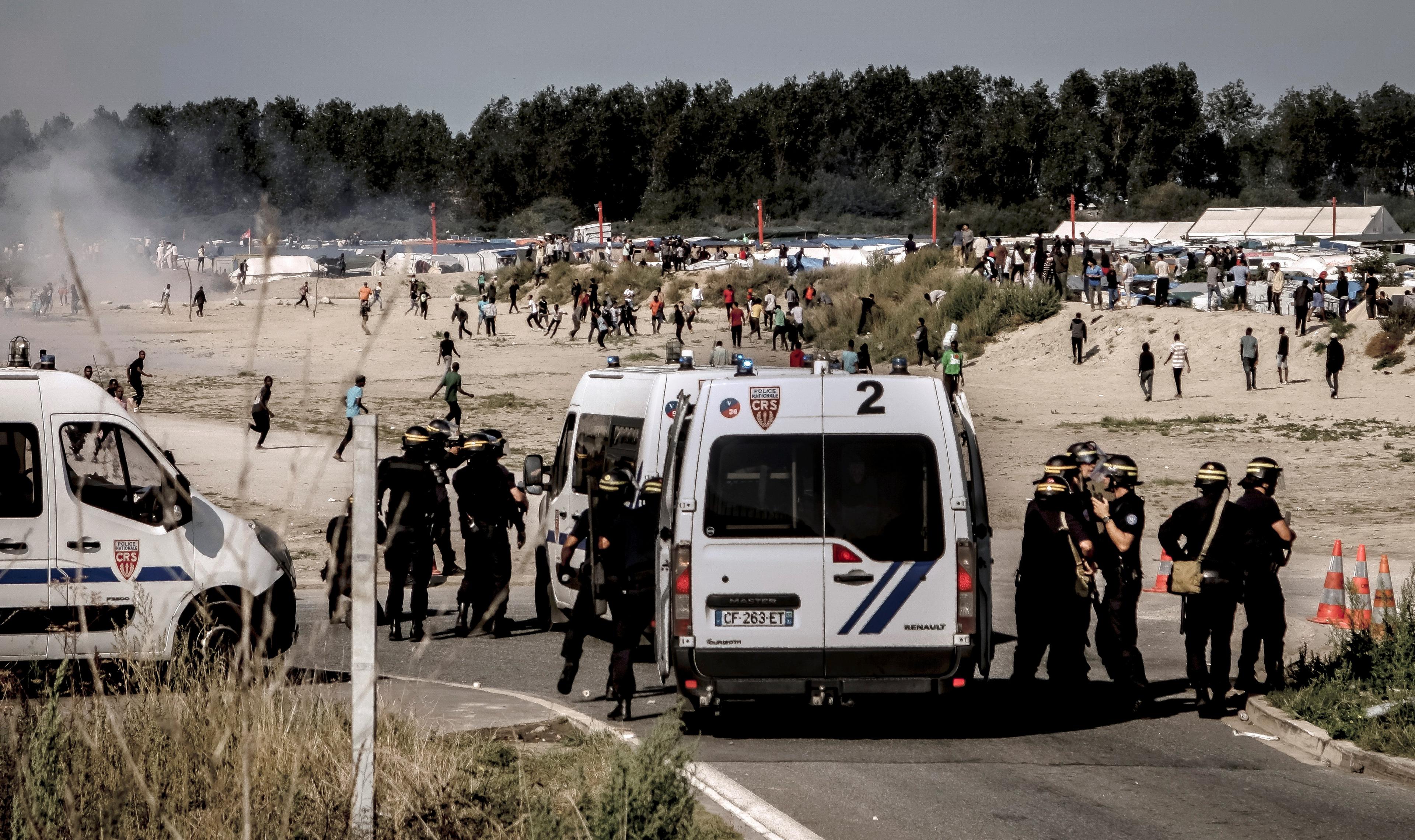 Kravallpoliser skingrar migranter som försöker ta sig ombord på lastbilar på väg till Storbritannien, i Calais den 21 september 2016. (Foto: Philippe Huguen/AFP/Getty Images)