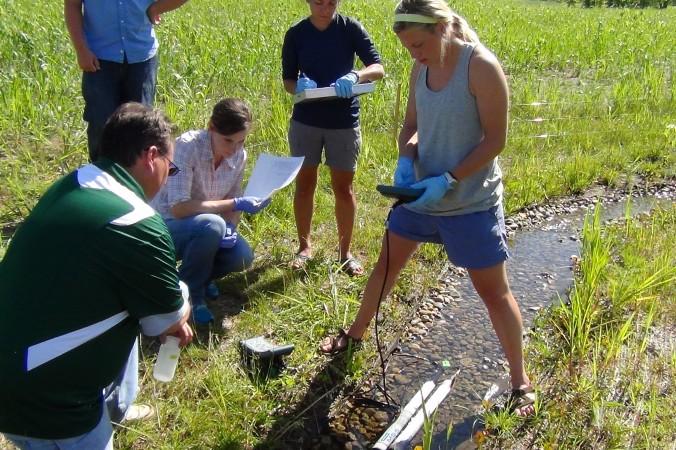 Studenter vid Notre Dame Linked Experimental Ecosystem Facility undersöker en bäck för att se om de hittar spår av genetiskt modifierade organismer. (Foto: Arial Shogren)