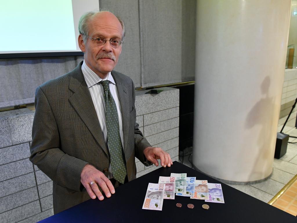 Riksbankens chef Stefan Ingves visar upp de nya mynten och sedlarna under en pressträff på Riksbanken i Stockholm. (Foto: Anders Wiklund/TT)