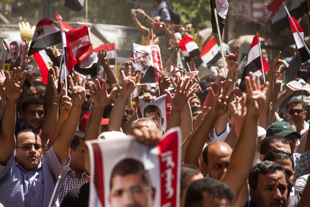 Muslimska brödraskapet-medlemmar håller upp en bild av Egyptens tidigare president Muhammad Mursi, som avsattes. (Foto: Belal Darder/AP/TT-arkivbild)