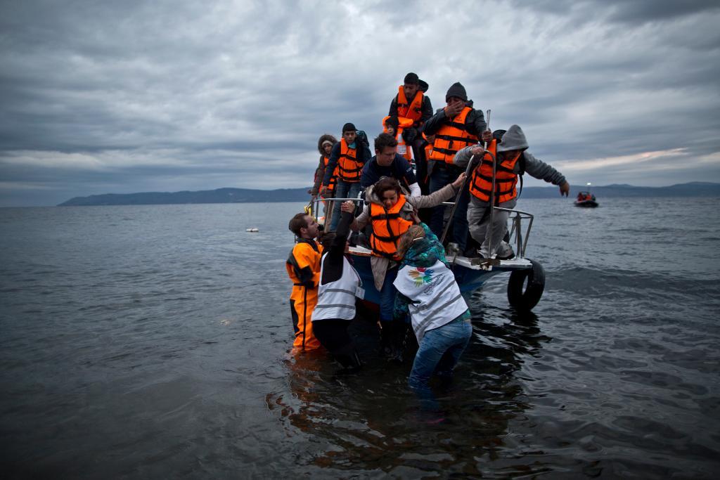 Grekiska öbor som räddar flyktingar anses ha goda chanser att få Nobels fredspris. Här hjälper frivilliga på ön Lesbos en irakisk familj. (Foto: Muhammed Muheisen/AP/TT-arkivbild)