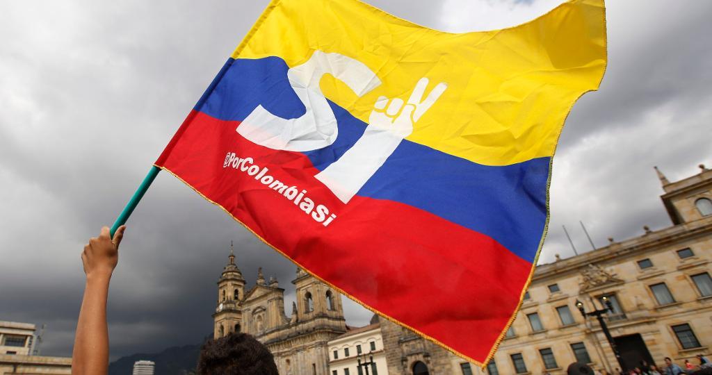 En anhängare till fredsavtalet mellan Farc och den colombianska regeringen viftar med en flagga.
(Foto: Fernando Vergara/AP/TT)