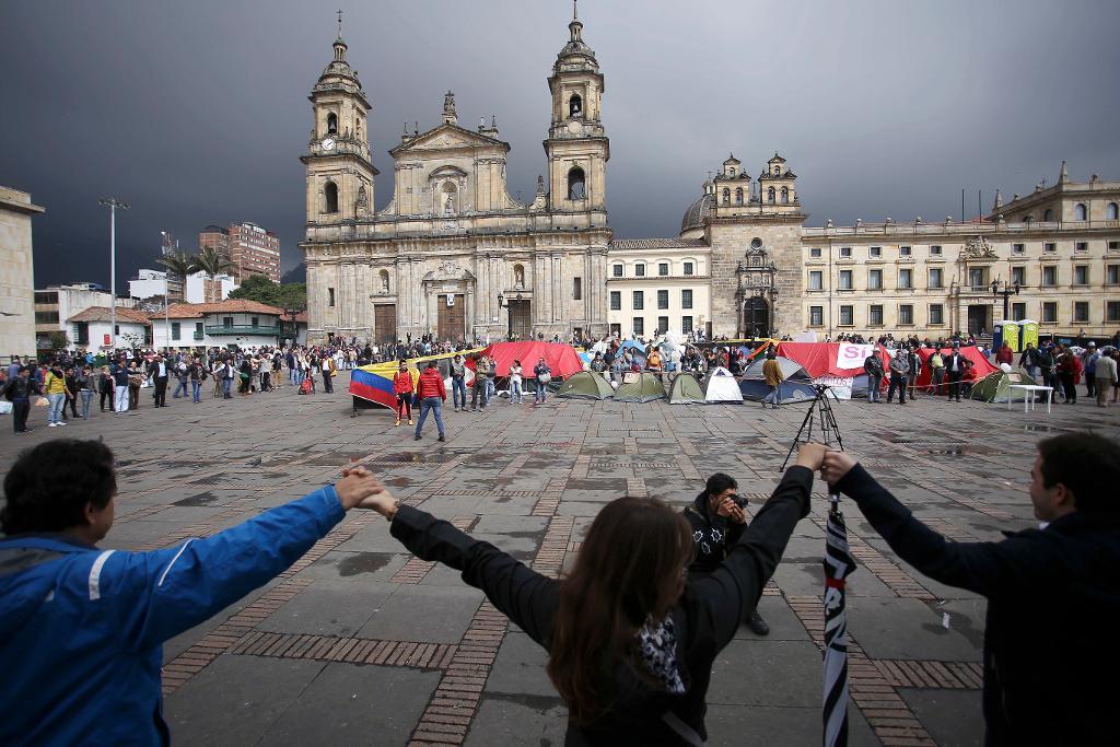 Demonstranter i Bogotá håller händer för att stödja fredsuppgörelsen mellan Colombia och Farc. (Foto: Ivan Valencia/AP/TT-arkivbild)