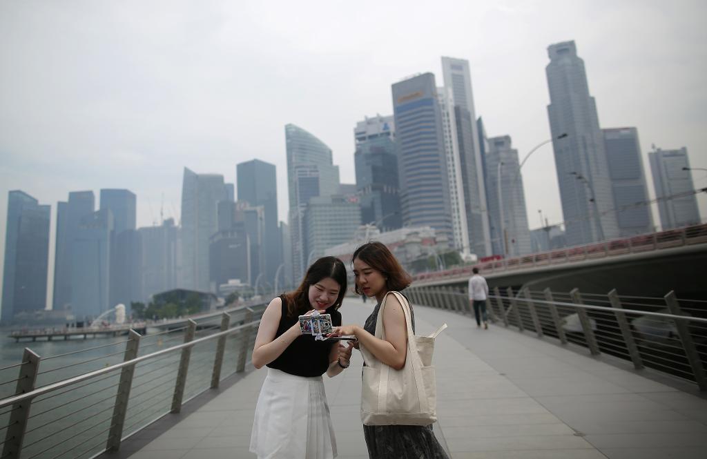 
Turister framför Singapores finansiella distrikt. (Foto: Wong Maye-E/AP/TT)