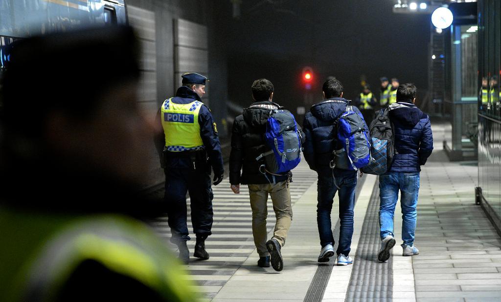 Polis eskorterar asylsökande från ett Öresundståg. Om den asylsökandes ålder är osäker, kan medicinska åldersbedömningar vara en användbar metod, enligt Statens medicinsk-etiska råd. (Foto: Johan Nilsson / TT-arkivbild)