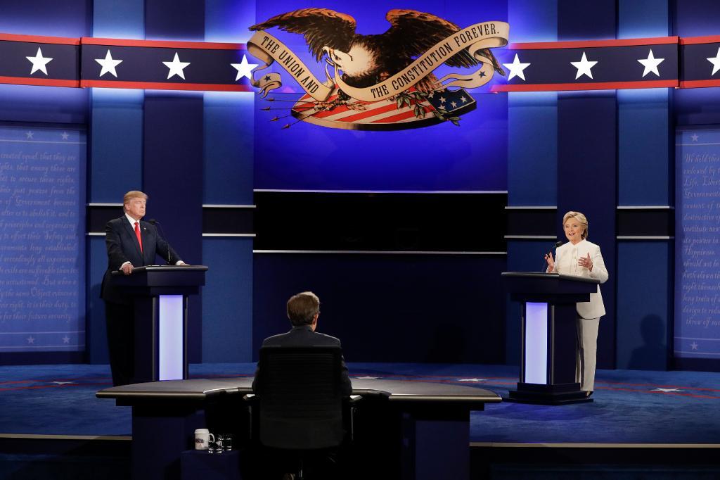 Clinton talar medan Trump lyssnar under nattens debatt, där stämningen bitvis var spänd. (Foto: John Locher/AP/TT)