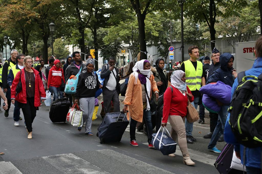 I Paris lever tusentals migranter på gatan. Vid metrostationen Stalingrad finns ett läger, som stadens borgmästare har begärt att polisen ska utrymma. Arkivbild från stängningen av ett migrantläger i norra Paris i september. (Foto: Thibault Camus/AP/TT)