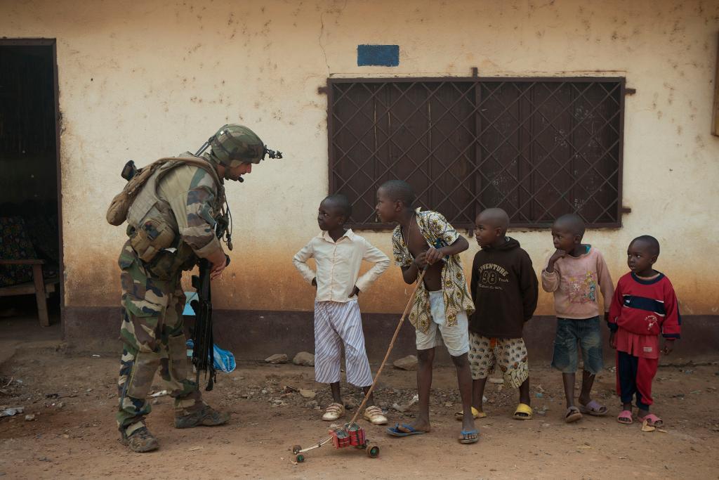 En fransk soldat i den centralafrikanska huvudstaden Bangui pratar med unga invånare. Nu avslutar Frankrike den militära insatsen som pågått sedan 2013. (Foto: Rebecca Blackwell/AP/TT)