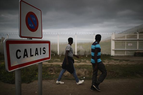 Barn från flyktinglägret går förbi en skylt i Calais, september 2016. Förra veckan attackerades fyra journalister när de spelade in reportage från flyktinglägret. (Foto: Christopher Furlong/Getty Images)