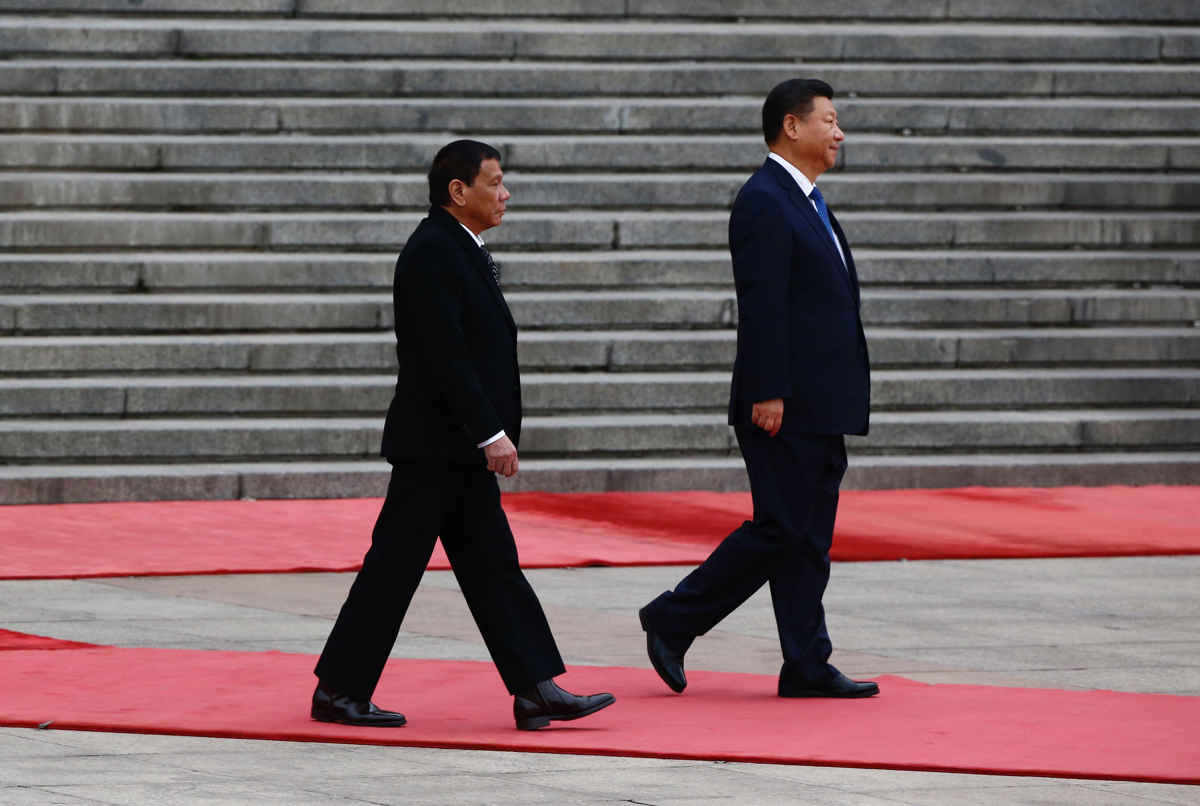Filippinernas president Rodrigo Duterte följer Kinas ledare Xi Jinping i spåren vid sitt besök i Peking  den 20 oktober. (Foto: Thomas Peter/AFP/Getty Images)