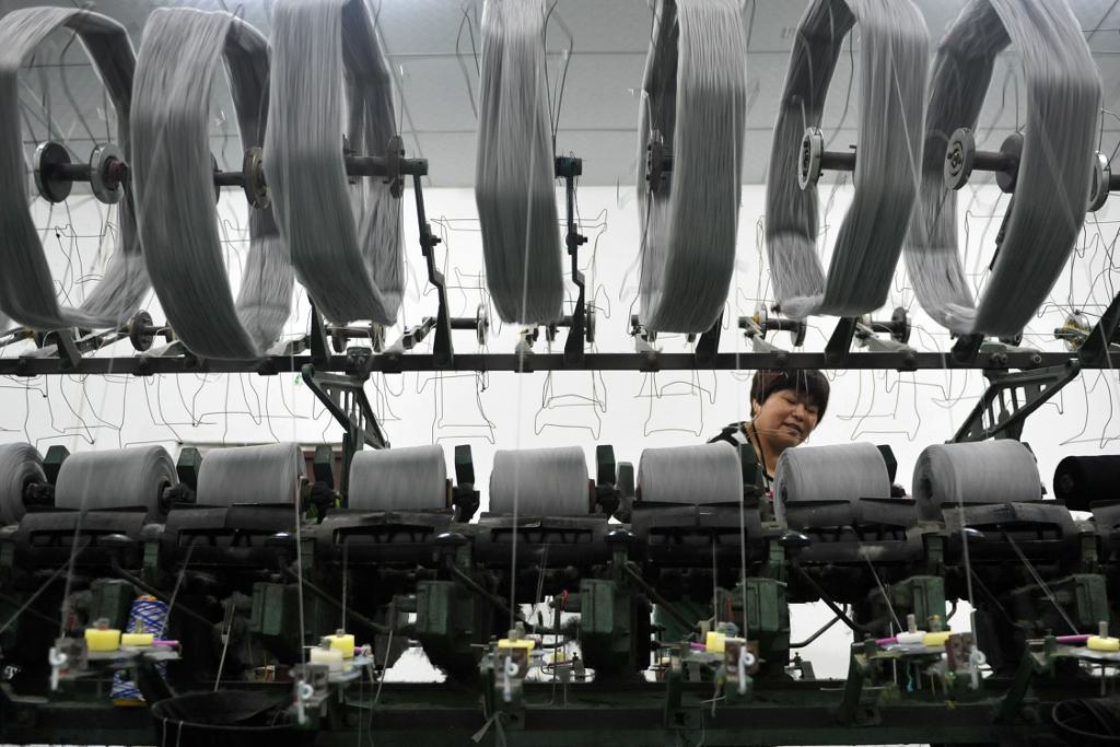 En arbetare vid en textilfabrik i Hangzhou i Kinas Zhejiangprovins.  (Foto: AP/TT-arkivbild)