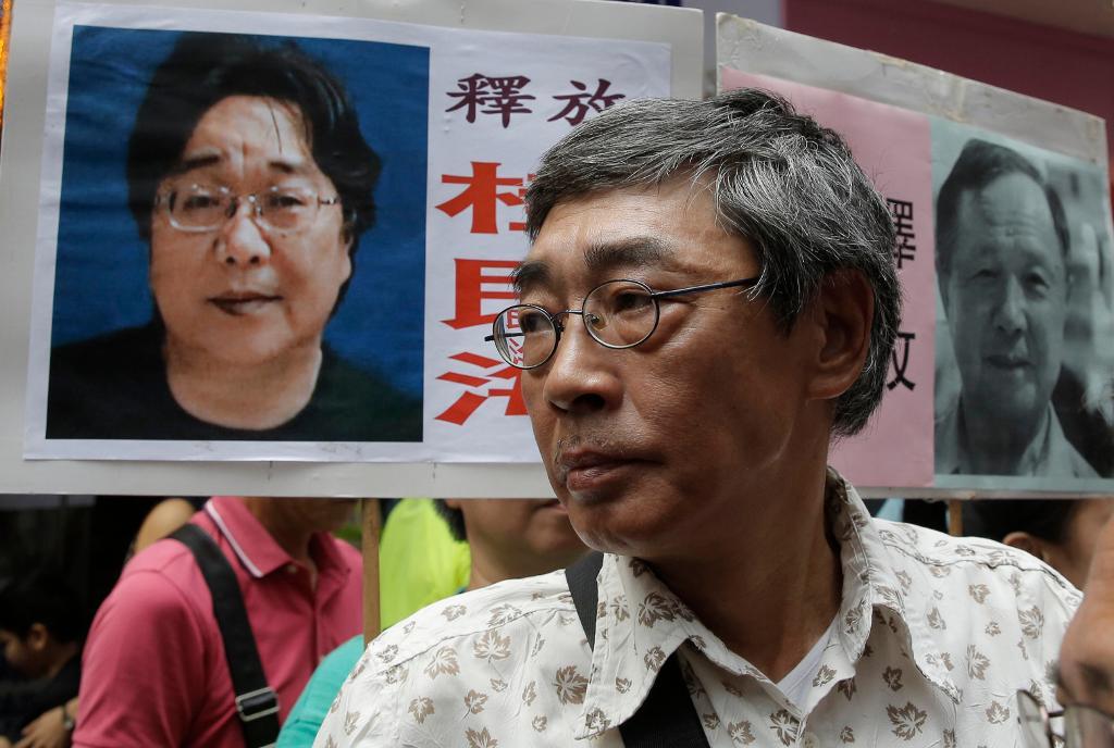 Frisläppte bokhandlaren Lam Wing-kee i Hongkong framför en bild på den försvunne svenske kollegan Gui Minhai. (Foto: Kin Cheung/AP/TT-arkivbild)