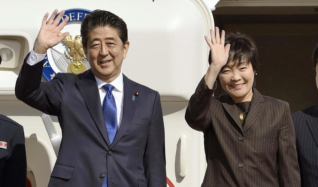 Japans premiärminister Shinzo Abe tillsammans med sin fru Akie vinkar hej då innan de kliver ombord på planet mot New York och Donald Trump. (Foto: Takuto Kaneko/AP/TT)