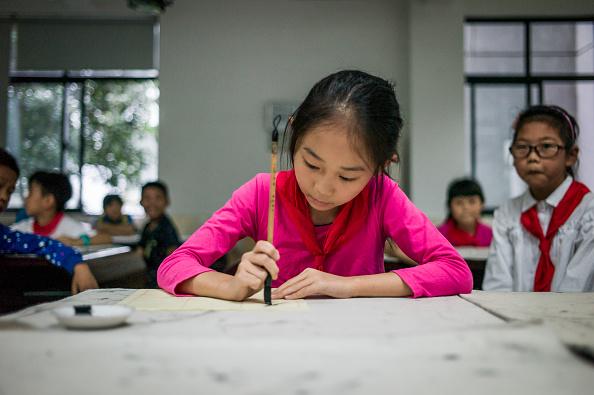En ung flicka skriver kinesiska tecken i en skola i Zhujiajiao i utkanten av Shanghai, Kina, den 8 september 2016. Shanghai ligger i topp i OECD:s Pisa-undersökningar. (Foto: Fred Dufour/AFP/Getty Images)