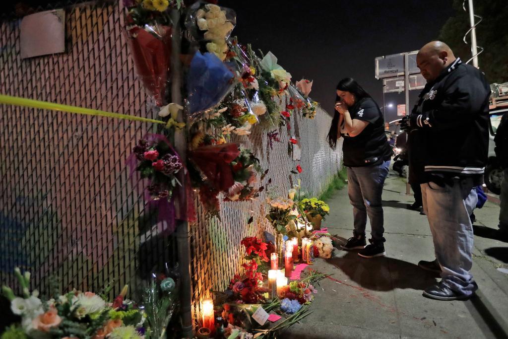 Sol Rodriguez och Aaron Torres tänder ljus för offren i Oakland. (Foto: Marcio Jose Sanchez/AP/TT)