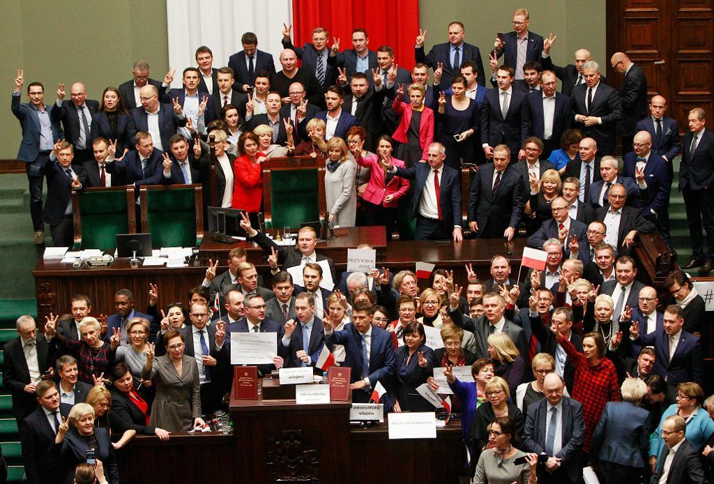 Parlamentsledamöter från oppositionen ockuperar podiet i det polska parlamentets underhus, sejmen, i Warszawa. (Foto: Czarek Sokolowski /AP/TT)