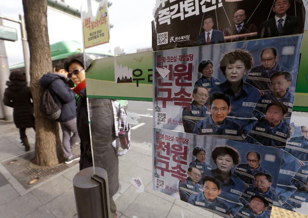 Park Geun-Hye, hennes nära medarbetare och affärsmän i ett fotomontage med fängelsekläder. Missnöjet med presidenten är massivt i Sydkorea. (Foto: Ahn Young-joon/AP/TT)