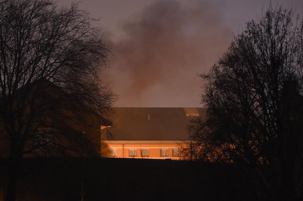 Rök stiger från fängelsebyggnaden i Birmingham där ett upplopp brutit ut. (Foto: Joe Giddens/AP/TT)