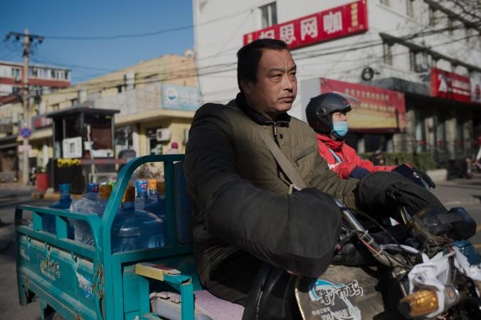 En man kör omkring med vattenbehållare på Pekings gator. Ekonomen Ma Guangyuan pekar ut den privata äganderätten som grunden för en fungerande ekonomi, och något som Kina måste komma tillrätta med om man vill uppnå varaktig ekonomisk tillväxt. (Foto: Nicolas Asfouri/AFP/Getty Images)