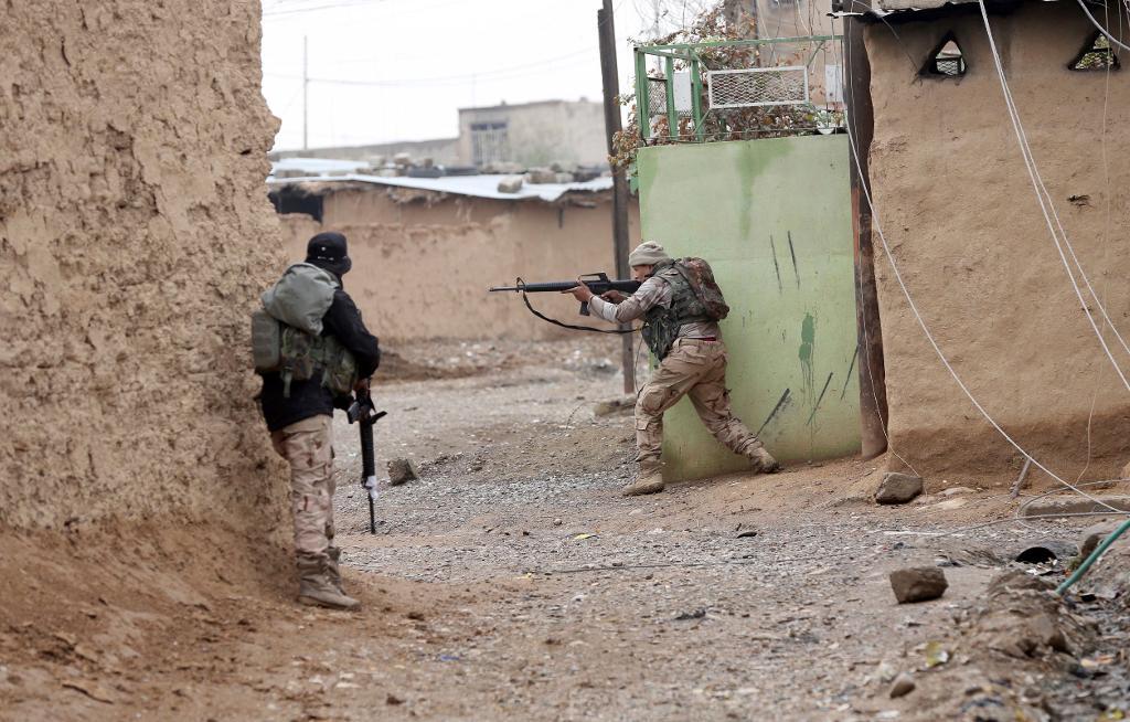 Irakiska regeringssoldater söker igenom en by utanför Mosul i Irak. (Foto: Hadi Mizban/AP/TT)