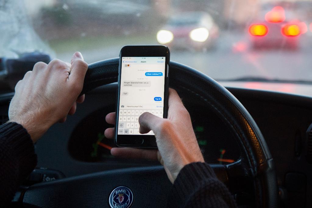 En man kör bil och skickar sms samtidigt. Arkivbild. (Foto: Erik Nylander/TT)