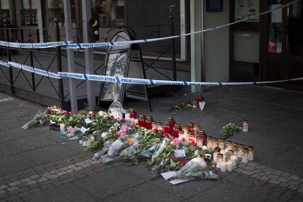 Blommor och ljus utanför restaurangen i Biskopsgården dagen efter skottlossningen då två personer dog och åtta skadades. (Foto: Björn Larsson Rosvall/TT)