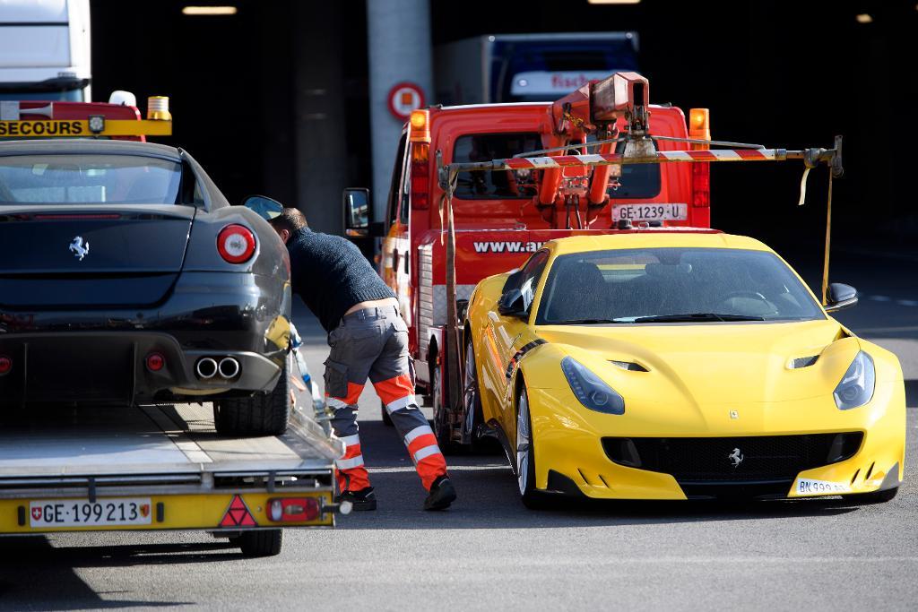 Myndigheter i Schweiz bogserar bort två Ferraribilar som beslagtagits i samband med utredningen mot Teodorin Obiang. (Foto: Laurent Gillieron/AP/TT-arkivbild)