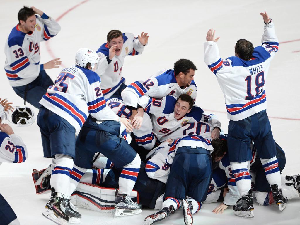 USA:s spelare i glädjehög efter att Troy Terry satt straffen som säkrade guldet i junior-VM i ishockey. (Foto: Paul Chiasson/Canadian Press/AP)