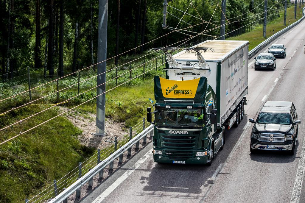 I Sverige invigdes i somras försök med en två kilometer lång elektrifierad sträcka på E16 utanför Sandviken. Tanken är att lastbilstransporter skall kunna gå på el ute på stomvägnätet och med förbränningsmotor i övrigt. (Foto: Pontus Lundahl/TT)