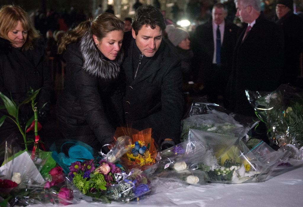 Premiärminister Justin Trudeau tillsammans med hustrun Sophie lägger ned blommor under en minnesstund i Québec. (Foto: Paul Chiasson/The Canadian Press/AP/TT)
