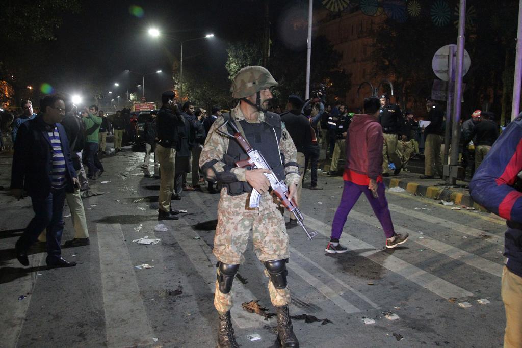 Polis- och säkerhetsstyrkor har spärrat av området i Lahore i Pakistan där en kraftig bomb detonerade. Foto: K.M. Chaudary/AP/TT