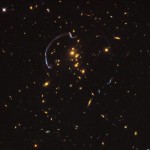En avlägsen galax, nästan 10 miljarder ljusår bort, tycks vara insvept i en närmare 90 graders ljusbåge i galaxklustret RCS2 032727-132623. (Foto från NASA, ESA, J. Rigby/NASA Goddard Space Flight Center, K. Sharon/Kavli Institute for Cosmological Physics, University of Chicago)