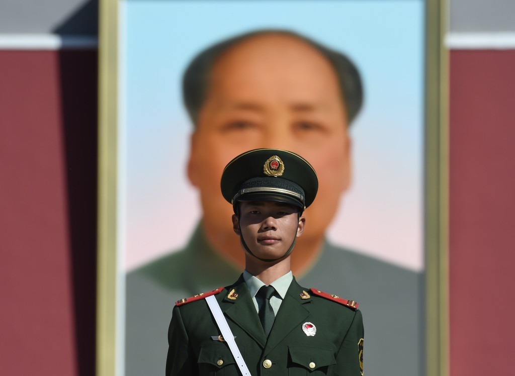 En paramilitärpolis står vakt framför porträttet av dåvarande kommunistledaren Mao Zedong på Himmelska fridens torg i Peking på Kinas nationaldag den 1 oktober 2015. (Foto: Greg Baker / AFP / Getty Images) 