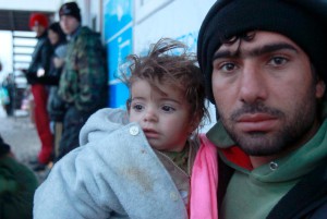 En irakisk flykting med sitt barn vilar ut efter att ha tagit sig till en tillfällig flyktingmottagning i norra Makedonien. (Foto: Boris Grdanoski/AP/TT)