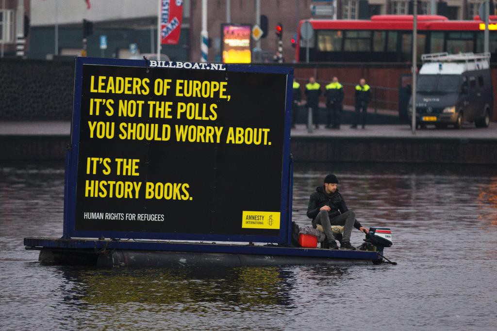 Aktivister från människorättsorganisationen Amnesty International protesterar med hjälp av båtar på Amsterdams kanaler i samband med måndagens ministermöte. (Foto: Peter Dejong/AP/TT)