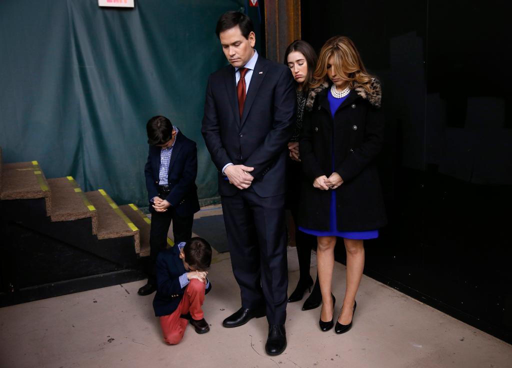 Presidentaspiranten Marco Rubio med familj ber en bön i samband med att ett av Republikanernas nomineringsmöten i Iowa startar. Rubio kom trea i delstaten. (Foto: Paul Sancya /AP/TT)