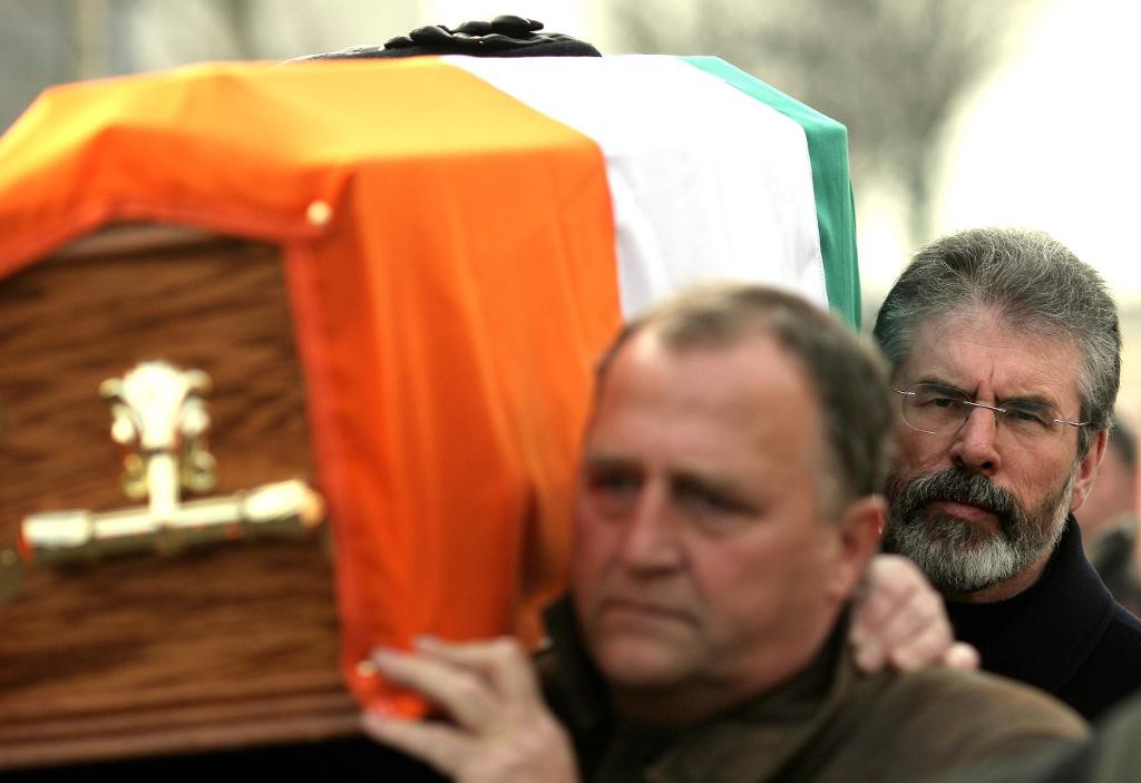 Vänsterledaren Gerry Adams (till höger) hoppas göra sitt Sinn Féin till största oppositionsparti i fredagens val på Irland. Många tvekar ändå om partiet, med tanke på dess koppling till våldsåren på Nordirland. På arkivbilden från 2008 deltar Adams i en begravning av mördade IRA-ledaren Brendan Hughes.(Foto: Peter Morrison /AP/TT)