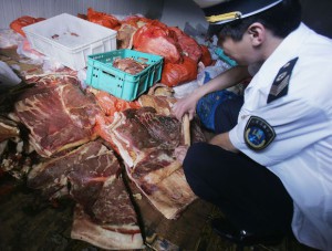 En kinesisk hälsovårdsinspektör kollar fläsk. (Foto: China Photos /Getty Images)