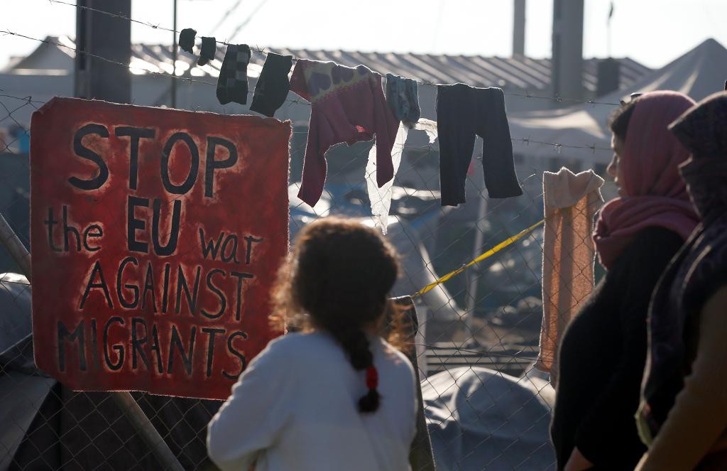 "Stoppa EU:s krig mot migranter" står det på en skylt i det grekiska lägret i Idomeni. (Foto: Darko Vojinovic /AP/TT-arkivbild)