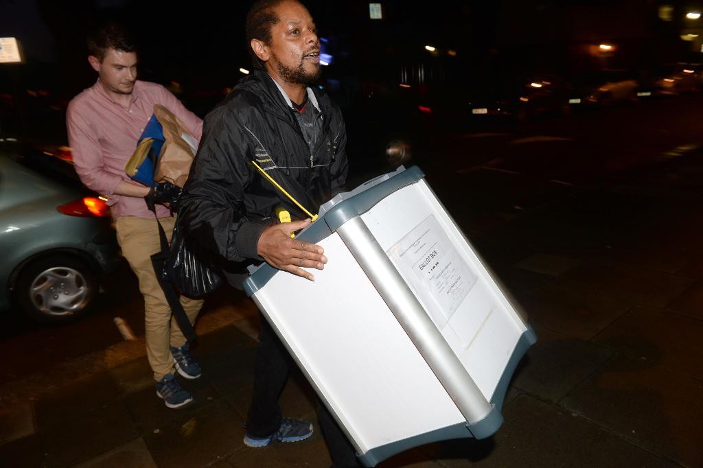 En låda med röstsedlar bärs i väg i London för att räknas. (Foto: Anthony Devlin /PA/AP/TT)