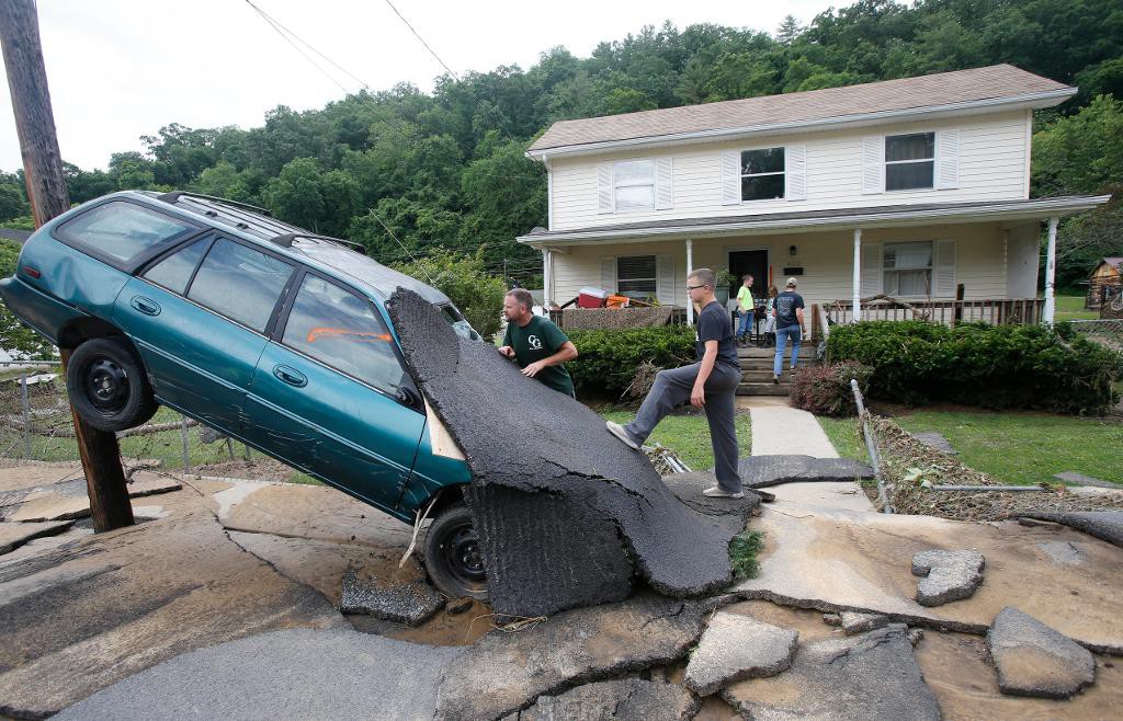 En man i White Sulphur Springs, West Virginia, röjer upp efter förstörelsen i översvämningarnas spår. (Foto: Steve Helber/AP/TT) 