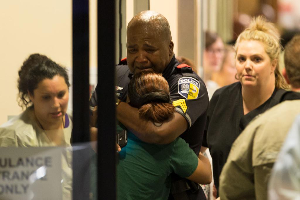 En polis i sorg efter att fyra av hans kollegor dödats och flera skadats i skottlossningar i Dallas. (Foto: Ting Shen/AP/TT)