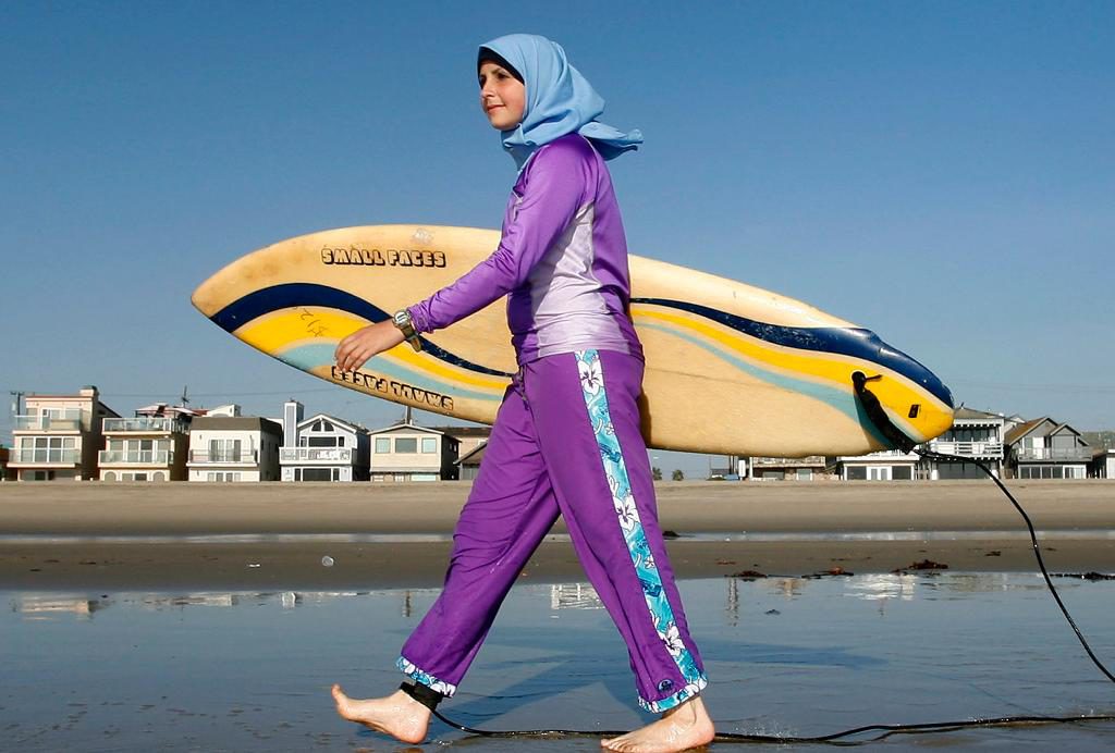 Aheda Zanetti kom på burkinin för att hon inte ville att troende, muslimska flickor skulle behöva avstå från strandsporter. På bilden syns en surfare i burkini i Kalifornien. Arkivbild. (Foto: Chris Carlson/AP/TT)