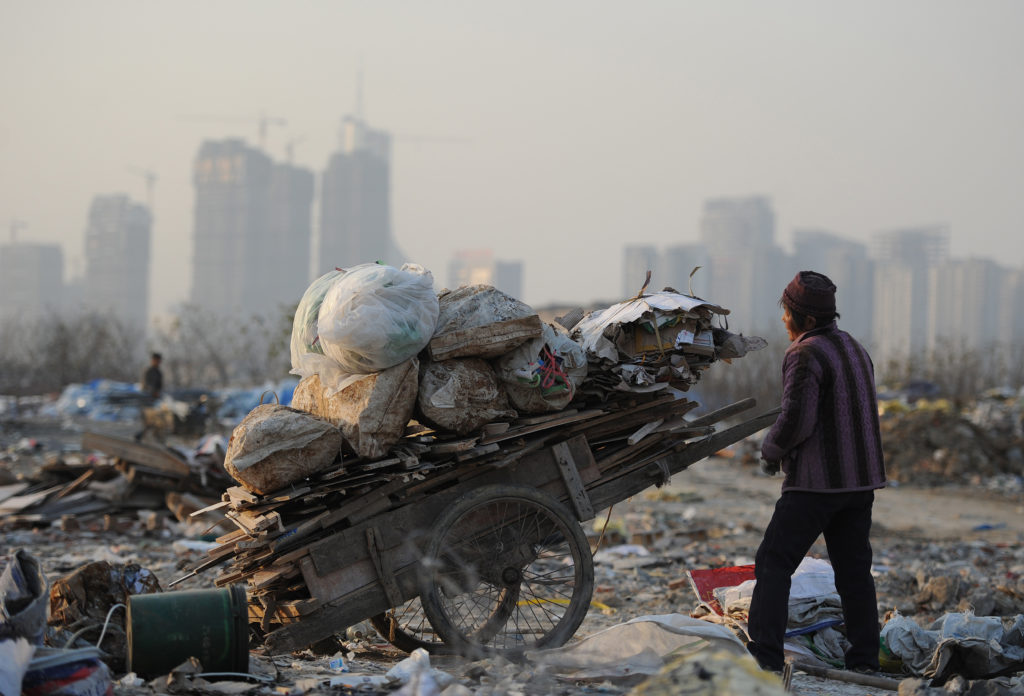 En informell ”renhållningsarbetare” tar hand om användbart byggmaterial på en soptipp i Hefei, Anhui-provinsen, i december 2012. (Foto: STR/AFP/Getty Images)
