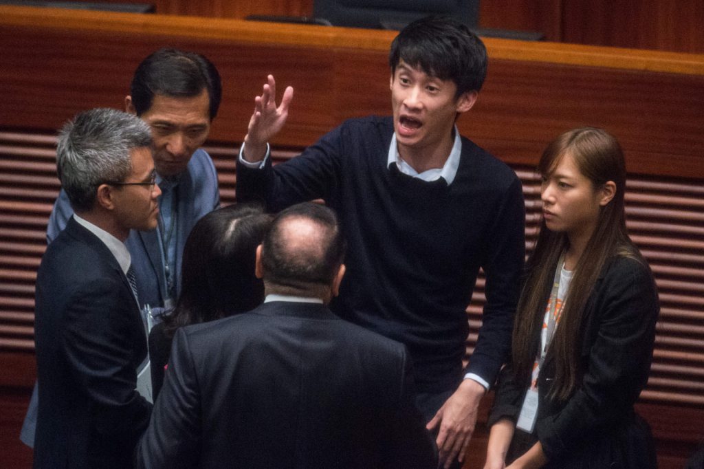 Sixtus "Baggio" Leung (mitten) gestikulerar under Hongkongs lagstiftande församlings möte den 12 oktober. Leung var en av de ledamöter som protesterade i samband med att de skulle sväras in i den lagstiftande församlingen. (Foto: Anthony Wallace/AFP/Getty Images)